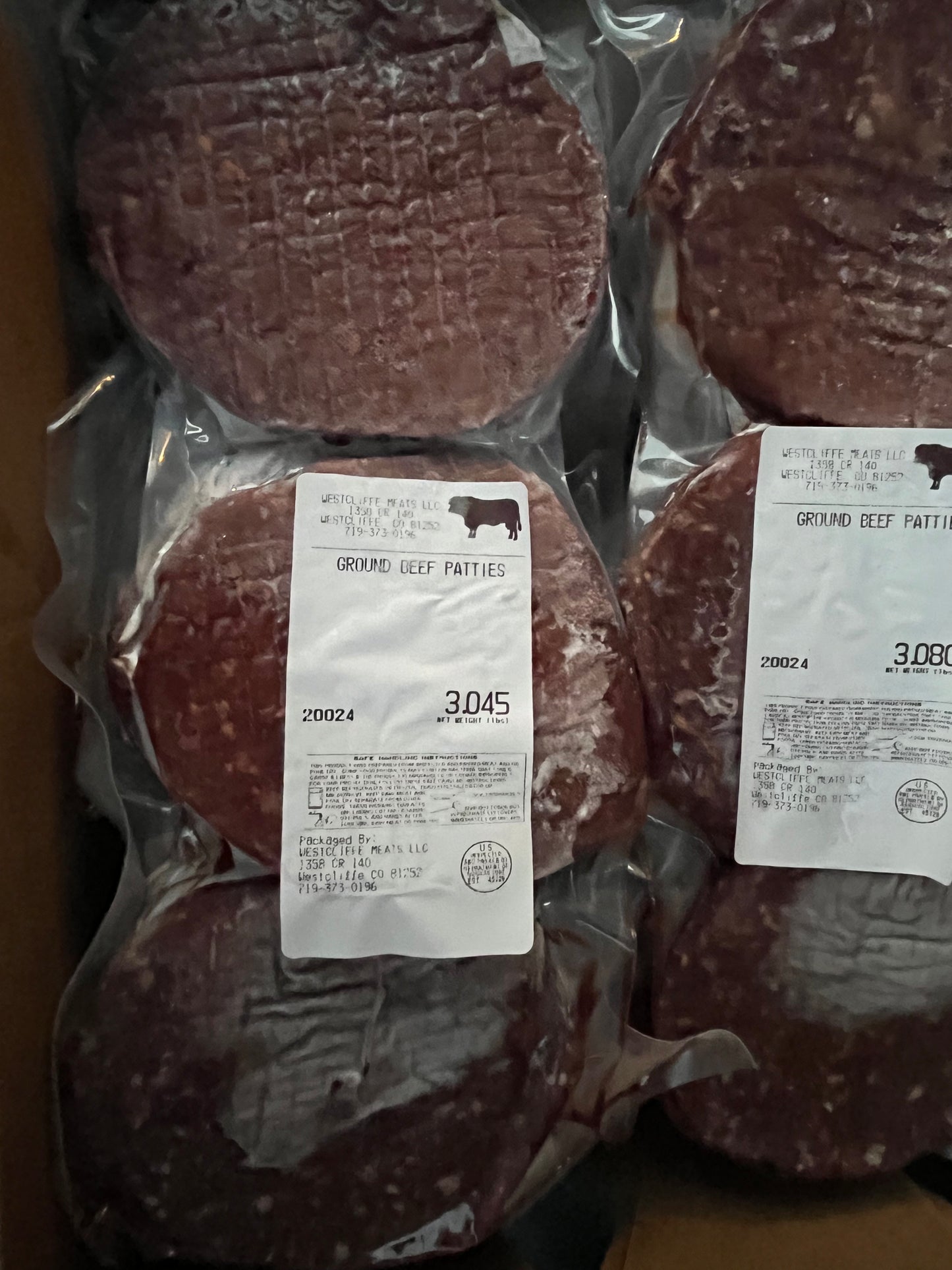 Eight Grass fed Grass finished Hamburger Patties (1/3lb each) from winterscattleranch, antibiotic- and hormone-free and rich in omega-3s, are vacuum-sealed with labels showing weight and price, arranged in a cardboard box.