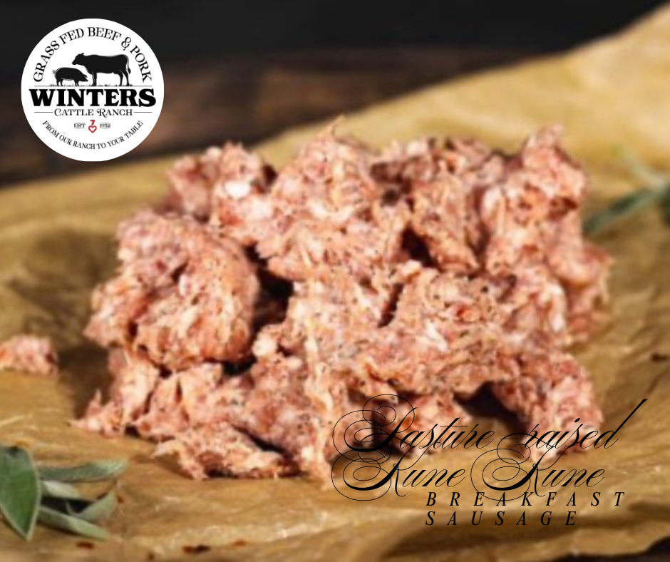 A pile of uncooked Winters Cattle Ranch Pasture Raised Ground Pork & Sausage sits on brown parchment paper with herbs nearby.