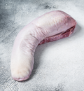 A fresh Winters Cattle Ranch Beef Tongue with pale, slightly textured skin and visible red muscle rests on a light gray textured surface.
